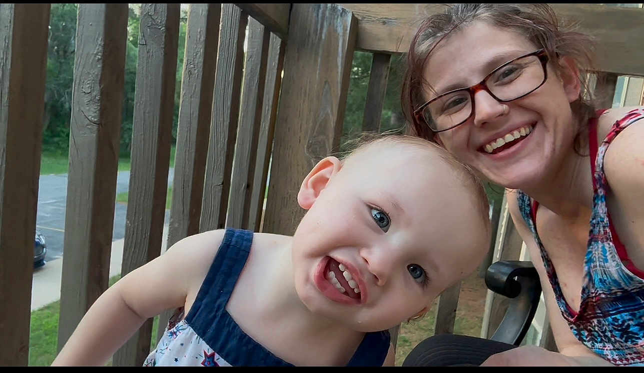 Baeleigh joined the competition — help win amazing prizes! toddler, child, woman, glasses, smiling, outdoor, balcony, wooden_railings, daylight, happy, portrait, casual, nature, greenery, person, face, summer_clothing, family, closeup, playful