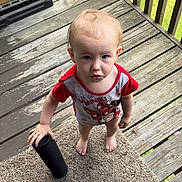 Baeleigh joined the competition — help win amazing prizes! toddler, child, barefoot, carpet, porch, wooden_floor, red_shirt, minnie_mouse, tumbler, standing, looking_up, expression, hand, flag, outdoor, railing, clothing, person, daylight, grass