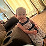 Baeleigh is registered to the contest to win money with this photo: toddler, child, smile, dress, remote_control, couch, carpet, indoor, lamp, curtains, sunlight, happy, person, furniture, home, cute, young_child, living_room, playful, daylight