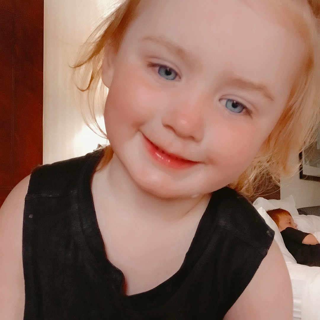 Piper is registered to the contest to win money with this photo: applique, baby, blonde, bodypart, child, clothing, dress, face, female, finger, girl, hair, hand, happy, head, person, photography, portrait, smile, t_shirt