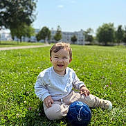 Arslan a rejoint le concours — aidez-le/la à gagner de superbes lots ! toddler, child, grass, outdoor, smile, soccer_ball, blue_ball, sunny_day, greenery, casual_clothing, sitting, happy, playing, park, nature, young_child, daylight, cute, person, recreation