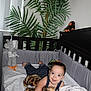 Eliott is registered to the contest to win money with this photo: baby, infant, crib, plush_toy, blanket, denim_overalls, smiling, indoor, stuffed_animal, plant, nursery, child, cute, happy, toddler, sleeping_area, toy, furniture, home, cozy