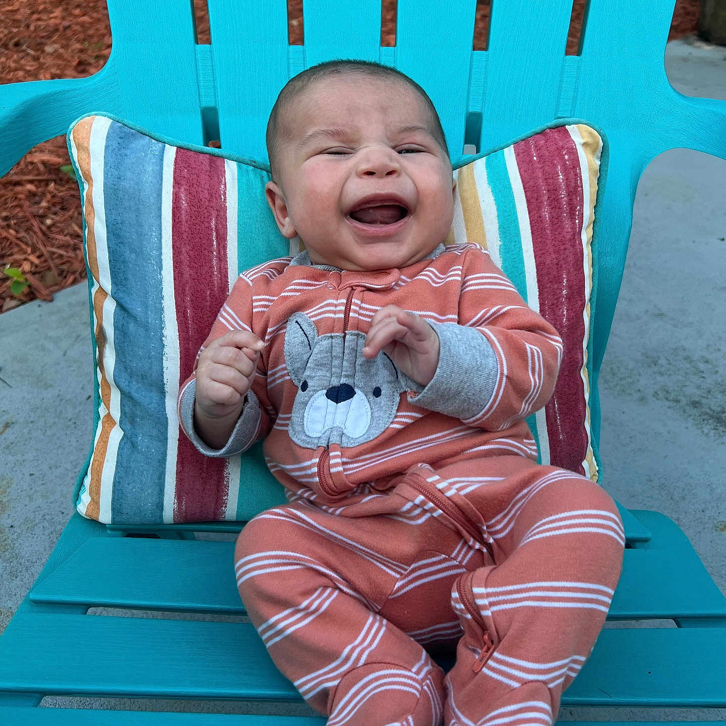 Jerry is registered to the contest to win money with this photo: baby, bear_design, blue, chair, child, colorful, concrete, daylight, happy, infant, mulch, nature, onesie, orange, outdoor, person, pillow, seat, smiling, striped_clothing