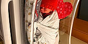 Jack is registered to the contest to win money with this photo: newborn, baby, hospital, bassinet, blanket, red_hat, sleeping, medical_equipment, pacifier, heart_pillow, swaddled, infant, cute, indoors, healthcare, monitoring_wires, crib, resting, child, cozy