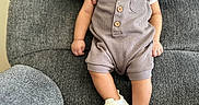 Iver Jr is registered to the contest to win money with this photo: baby, infant, child, hands, romper, sneakers, smile, couch, gray, fabric, person, support, seated, indoor, cute, small, happy, casual, portrait, comfort