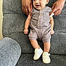 baby, infant, child, hands, romper, sneakers, smile, couch, gray, fabric, person, support, seated, indoor, cute, small, happy, casual, portrait, comfort