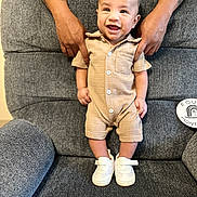 Iver Jr joined the competition — help win amazing prizes! baby, smiling, romper, white_sneakers, tattooed_hands, gray_armchair, supporting_hands, happy, child, infant, seated, indoors, textured_clothing, cute, person, footwear, portrait, baby_fashion, comfortable, joyful