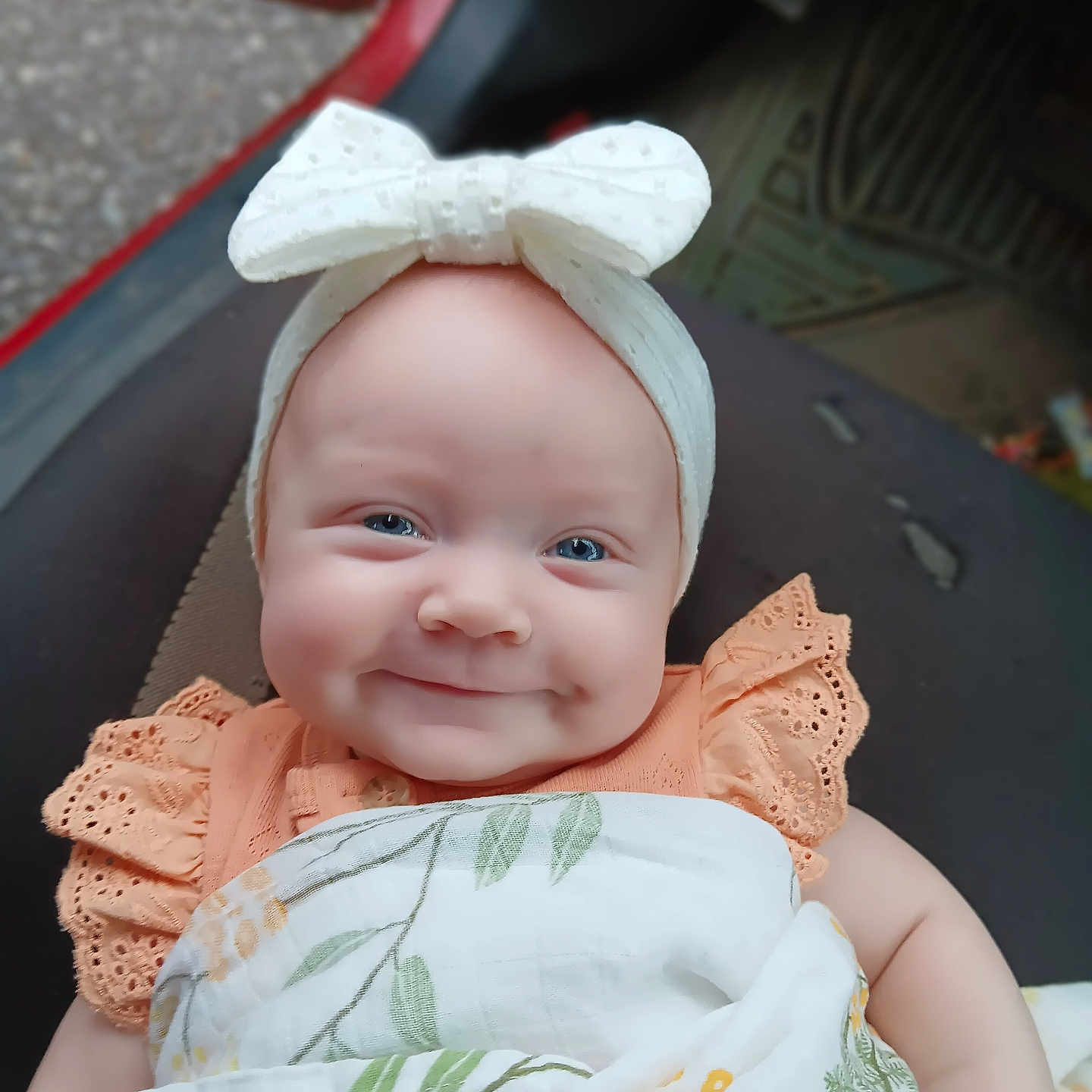 Priscilla joined the competition — help win amazing prizes! baby, blanket, blue_eyes, bow, child, closeup, clothing, cute, fabric, happy, headband, indoor, infant, orange_dress, pattern, person, portrait, seat, smiling, soft_light