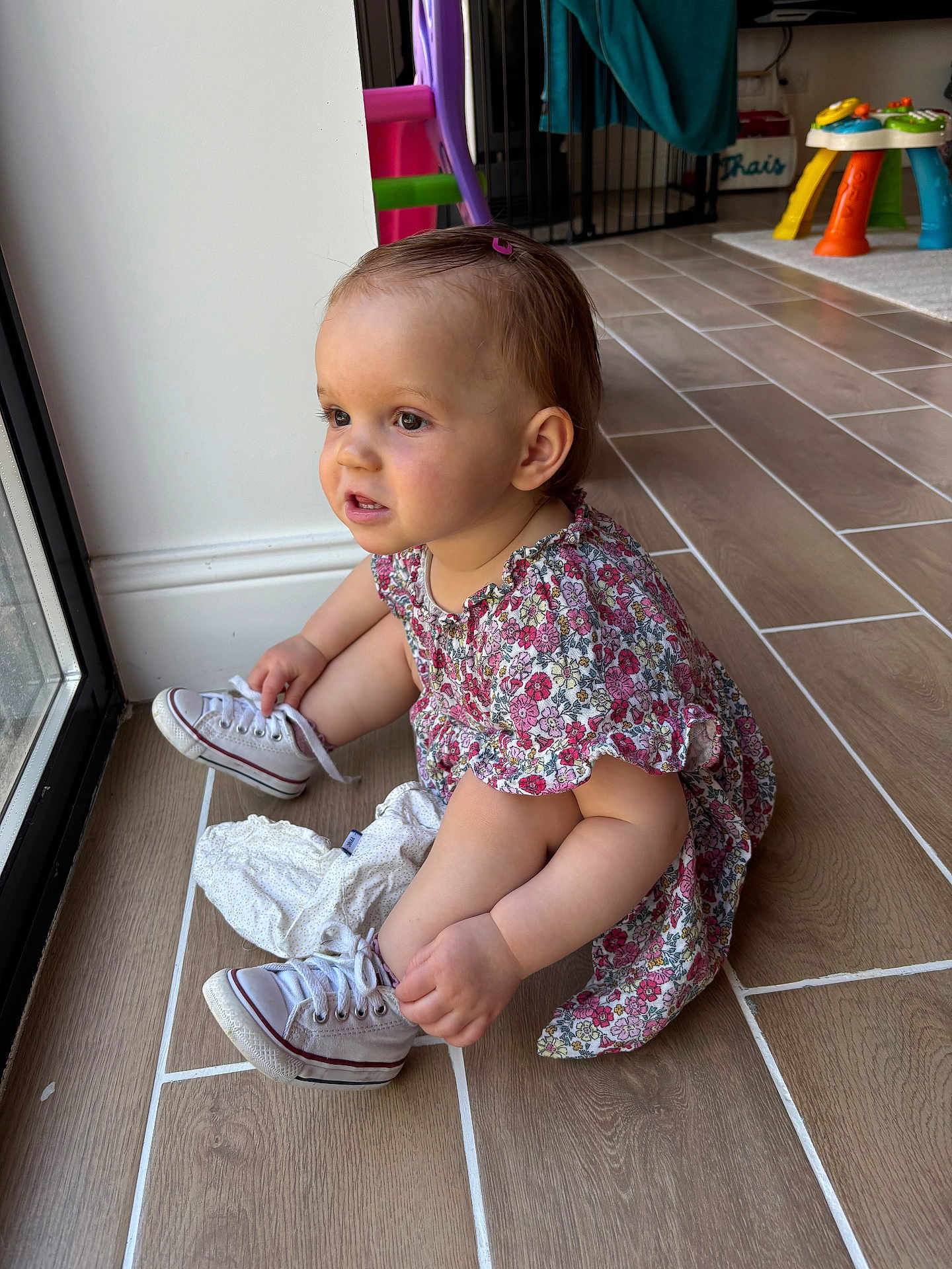 Thaïs a rejoint le concours — aidez-le/la à gagner de superbes lots ! toddler, child, baby, dress, sneakers, floor, window, indoor, toy, play_area, hair_clip, person, footwear, converse, sitting, curious, light, natural_light, home, tile_floor