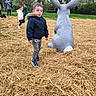 Kelyan a rejoint le concours — aidez-le/la à gagner de superbes lots ! boy, casual, child, curious, daytime, fun, grass, jacket, kids, nature, outdoor, park, people, play, rabbit, sculpture, sneakers, statue, straw, trees
