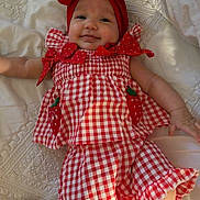 Ainhoa joined the competition — help win amazing prizes! baby, child, infant, portrait, smiling, happy, lying_down, red_bow, headband, gingham_dress, red_and_white, polka_dots, quilt, bed, indoors, fashion, cute, arms, hands, family_photo