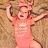 baby, infant, pink_onesie, headband, bow, smiling, happy, blanket, soft_texture, cute, child, portrait, lying_down, raised_arms, cheerful, indoors, cozy, infant_clothing, person, closeup