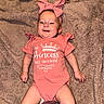 baby, infant, girl, smiling, headband, pink_clothing, onesie, blanket, soft_texture, lying_down, happy, cute, child, small_hands, small_feet, indoor, portrait, face, sock, adorable