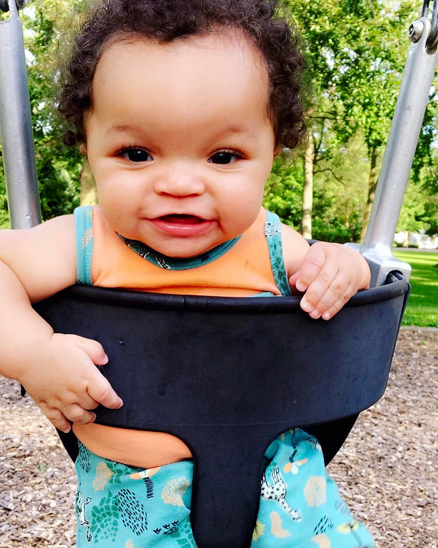 Giovani is registered to the contest to win money with this photo: abdomen, baby, baby_products, baby_toddler_clothing, beauty, black_hair, cheek, child, child_model, face, happy, outdoor_play_equipment, pattern, person, play, playground, skin, smile, summer, swing