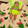 baby, infant, fairy_costume, green_wings, pink_tulip, flowers, butterflies, blanket, headband, smiling, cute, child, indoors, soft_texture, playful, costume, shoes, green, pink, decorative