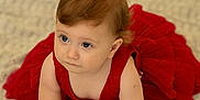 Elizabeth is registered to the contest to win money with this photo: baby, child, red_dress, crawling, blue_eyes, blanket, indoors, golden_balloons, curious, soft_lighting, hands, face, hair, cute, portrait, infant, floor, celebration, young, skin
