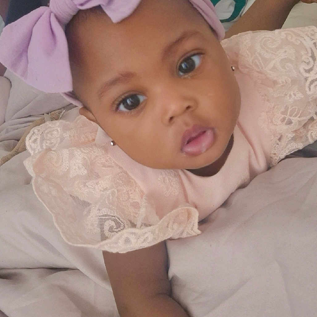 Shaïyna-Mony a rejoint le concours — aidez-le/la à gagner de superbes lots ! baby, child, headband, bow, pink_dress, lace, bed, blanket, person, face, portrait, indoor, curious, cute, infant, sibling, family, clothing, young_child, relaxed
