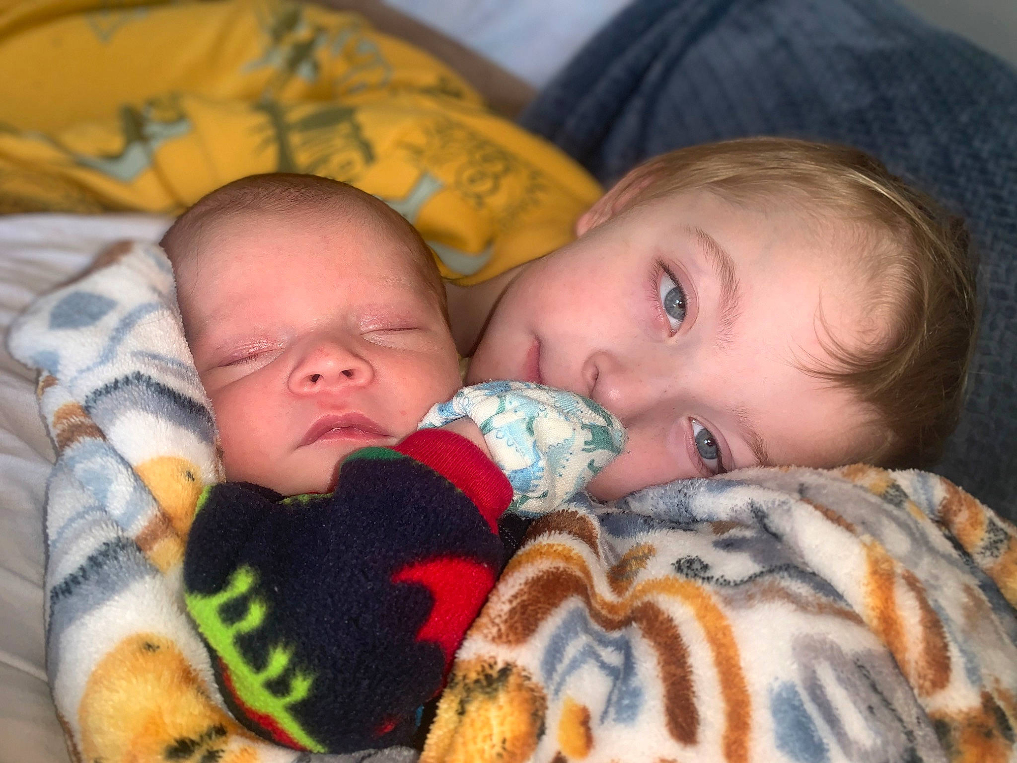 Liam is registered to the contest to win money with this photo: baby, baby_toddler_clothing, cheek, child, chin, comfort, eye, face, facial_expression, hand, head, iris, linens, lip, mouth, nose, organ, person, skin, textile