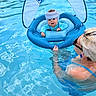 baby, child, swimming_pool, water, float, inflatable, helmet, adult, woman, sunglasses, sunshade, blue, summer, fun, outdoor, safety, care, person, swimwear, happy