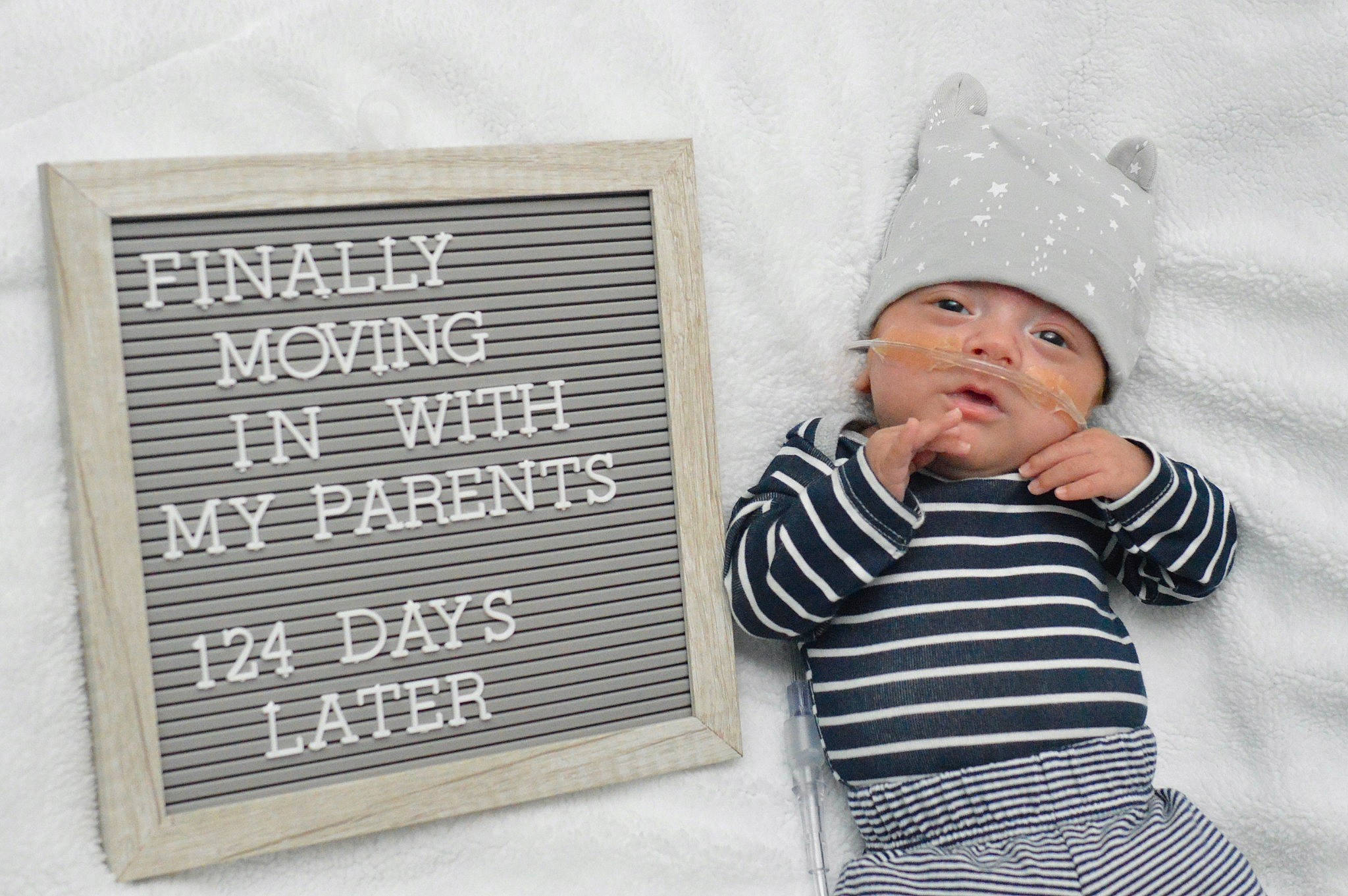 Manuel is registered to the contest to win money with this photo: baby, baby_toddler_clothing, beanie, cap, child, comfort, font, grey, happy, headgear, headwear, knit_cap, linens, pattern, person, rectangle, room, sitting, sleeve, street_fashion