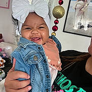 Feyre joined the competition — help win amazing prizes! baby, child, denim_jacket, headband, white_bow, smiling, indoor, person_holding, portrait, happy, face, hand, clothing, room, decorations, framed_photo, family, cute, casual, toddler