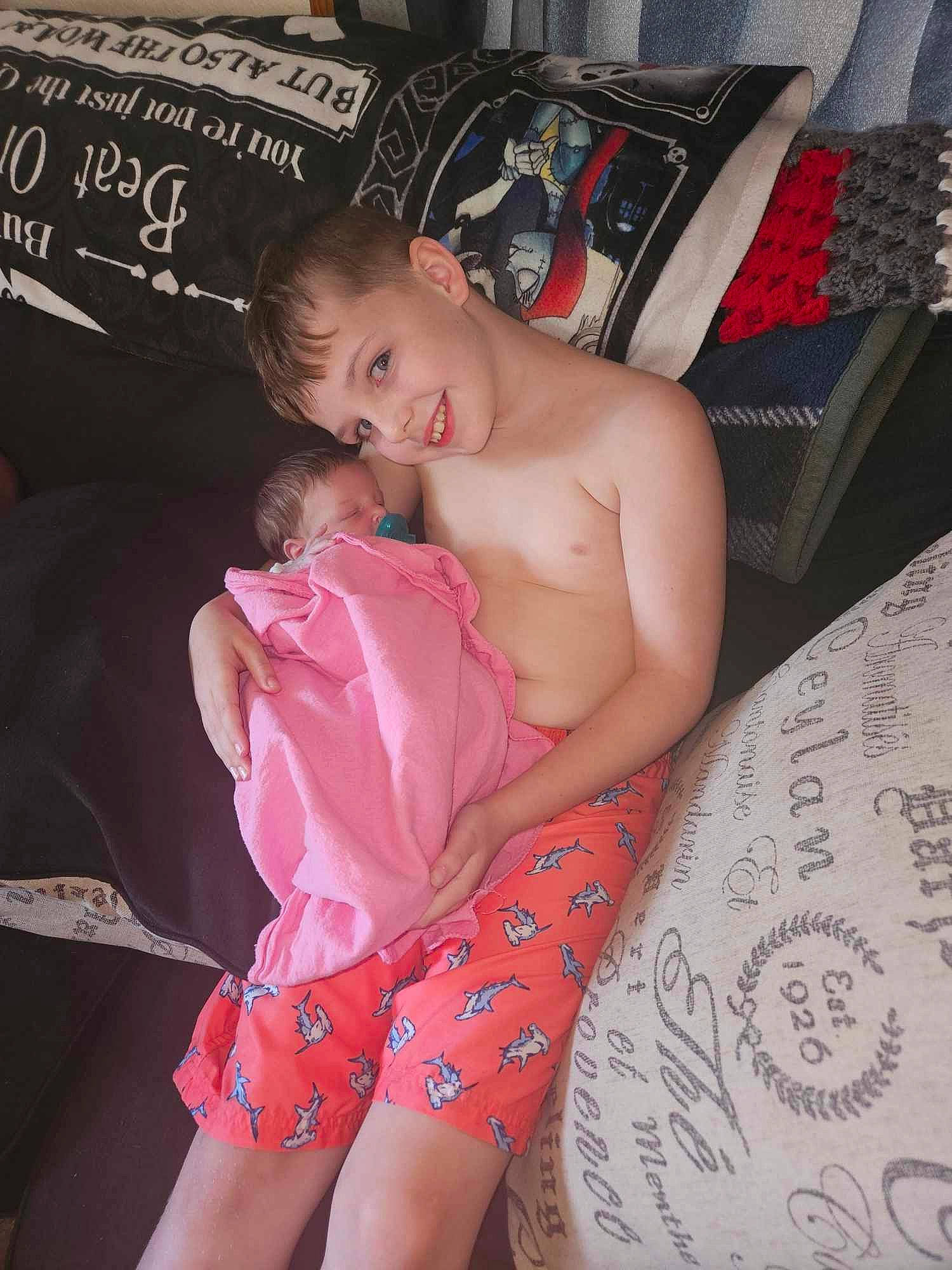 Breanna is registered to the contest to win money with this photo: abdomen, baby, barechested, barefoot, chair, chest, comfort, event, fashion, finger, human_body, human_leg, joy, lap, leg, muscle, person, skin, stomach, textile