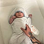 baby, towel, hood, tattoo, hand, diaper, changing_pad, infant, wrapped, newborn, skin, person, bed, blanket, resting, cute, indoors, care, parent, soft