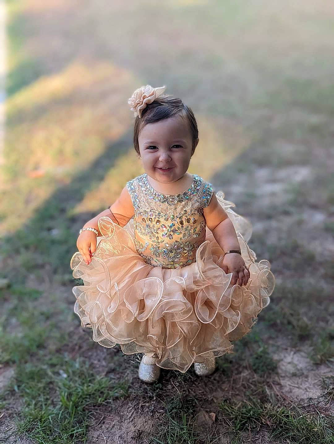Nora is registered to the contest to win money with this photo: baby, baby_toddler_clothing, day_dress, dress, embellishment, eye, face, flash_photography, fun, grass, grass_family, grassland, happy, headgear, headpiece, joy, people_in_nature, person, plant, smile