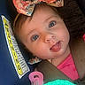 Brynleigh joined the competition — help win amazing prizes! baby, child, face, tongue_out, bow, colorful_bow, car_seat, pacifier, toy, warning_label, close_up, pink_clothing, blue_background, straps, infant, cute, playful, seatbelt, portrait, young