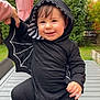 Mira a rejoint le concours — aidez-le/la à gagner de superbes lots ! toddler, child, costume, bat_wings, hoodie, black_clothing, smile, outdoor, table, barefoot, garden, greenery, umbrella, person, cute, happy, playful, baby, clothing, portrait