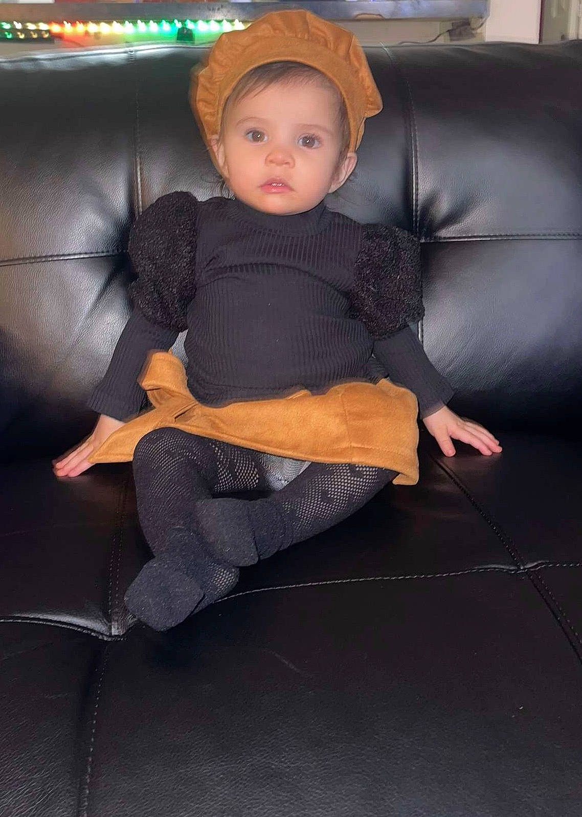 Aria is registered to the contest to win money with this photo: baby, child, comfort, couch, fashion_accessory, fedora, flooring, fun, hat, headwear, human_leg, knee, lap, person, room, sitting, sleeve, sock, sun_hat, thigh