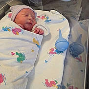 Rylie is registered to the contest to win money with this photo: newborn, baby, infant, sleeping, blanket, hospital, bassinet, hat, swaddled, bed, face, peaceful, resting, blue_bulb_syringe, reflection, soft_lighting, cute, toddler, child, person