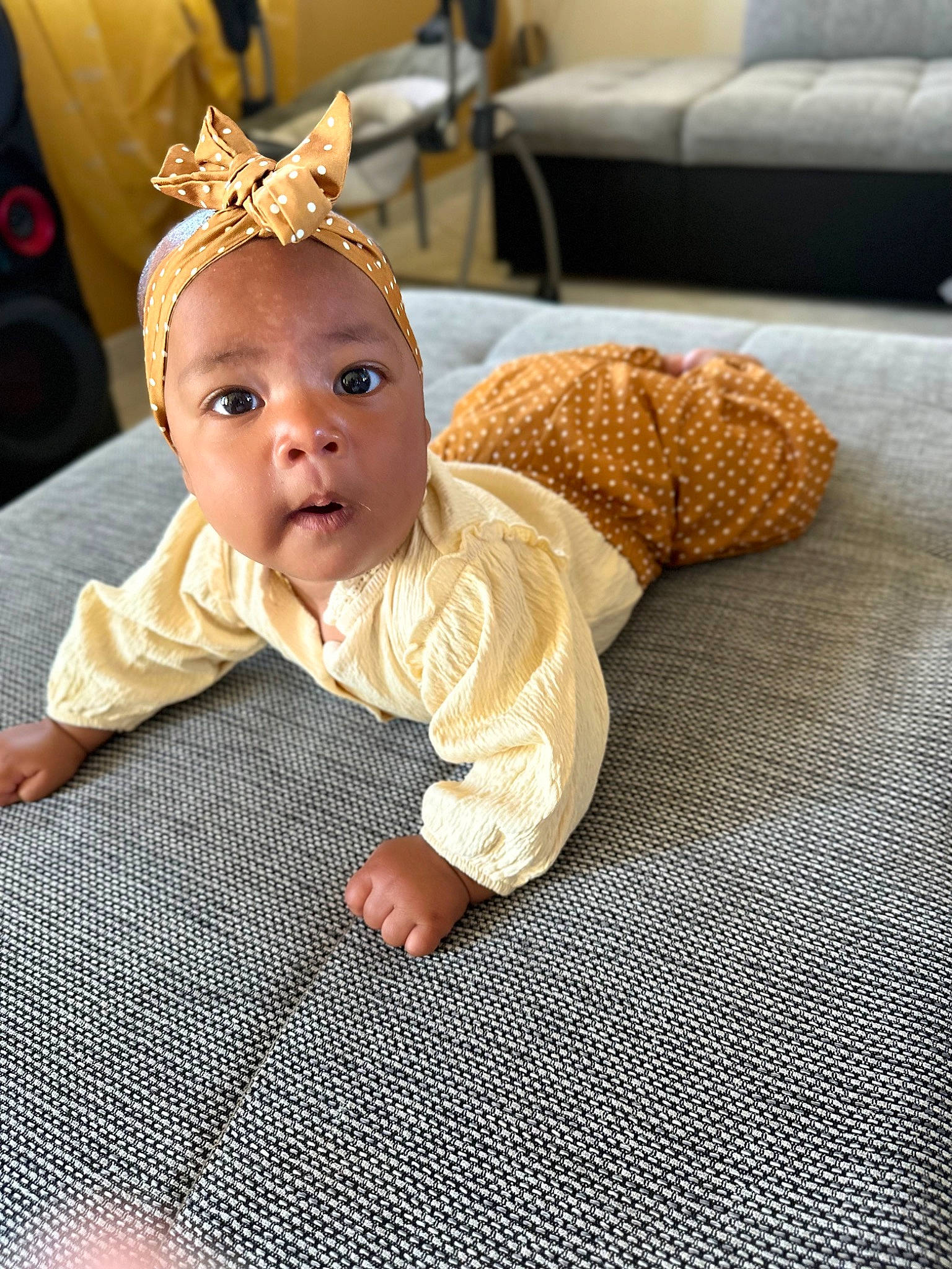 Naïla participe au concours pour gagner de l'argent avec cette photo : baby, baby_products, baby_sleeping, baby_toddler_clothing, child, comfort, costume_hat, couch, flooring, happy, headgear, headpiece, knit_cap, linens, person, room, sitting, skin, surprise, toddler