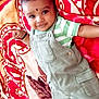 Vishakan is registered to the contest to win money with this photo: baby, child, infant, smiling, face, eyes, clothing, overalls, striped_shirt, blanket, pattern, colorful, lying_down, cute, portrait, hand, bangle, skin, indoors, happy