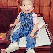 Aubree joined the competition — help win amazing prizes! toddler, child, smiling, denim_overalls, pink_bows, white_shoes, changing_table, wooden_wall, indoor, baby, cute, happy, sitting, person, furniture, face, young_child, hair_bows, footwear, apparel