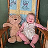 baby, child, toddler, smiling, sitting, teddy_bear, stuffed_animal, wooden_chair, quilt, cushion, indoors, portrait, home, furniture, infant, romper, barefoot, happy, green_wall, photography