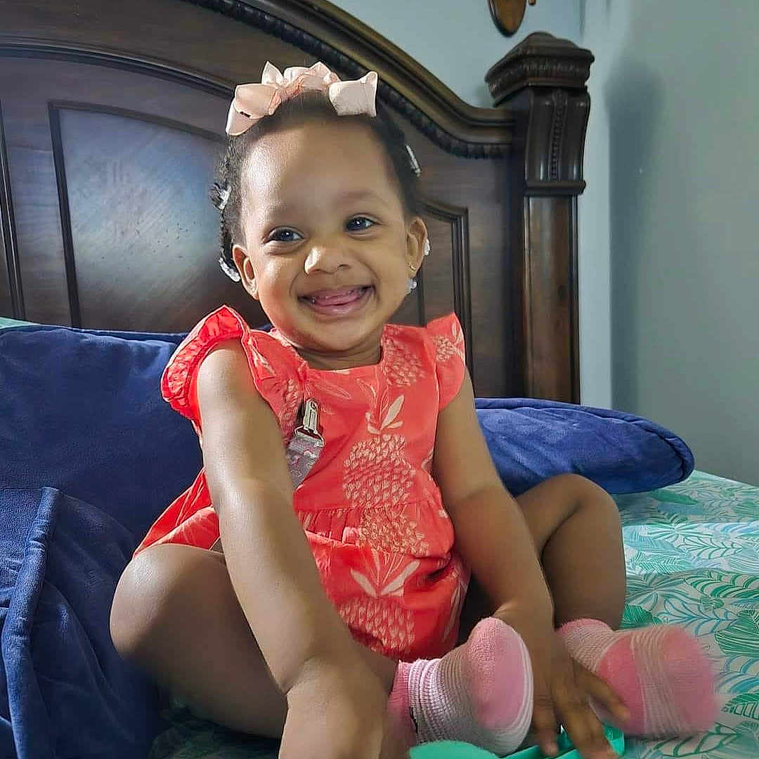 Charleigh is registered to the contest to win money with this photo: baby, bed, bedroom, clothing, cushion, device, face, furniture, happy, head, homedecor, indoors, person, photography, portrait, room, shovel, sitting, smile, tool