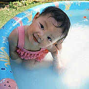 Kianna joined the competition — help win amazing prizes! baby, child, cute, face, garden, grass, head, inflatable_pool, outdoor, pink, playful, pool, sitting, smiling, summer, sunny, swimsuit, toddler, water, wet_hair