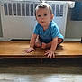 toddler, child, blue_shirt, wooden_shelf, indoor, floor, radiator, curious, crouching, hands, feet, light, window, curtain, home, person, young_child, flooring, wood, expression