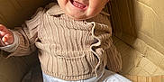 Arthur is registered to the contest to win money with this photo: baby, blue_eyes, cardboard_box, child, clothing, cozy, cute, face, fun, happy, indoors, infant, light, pants, person, playful, sitting, smiling, sweater, warm