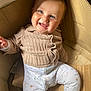 baby, child, smiling, blue_eyes, sweater, pants, cardboard_box, sitting, happy, cute, indoors, cozy, infant, face, person, clothing, warm, fun, playful, light