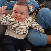 Jayden participe au concours pour gagner de l'argent avec cette photo : baby, child, couch, smiling, phone, indoor, sitting, striped_shirt, blue_pajamas, socks, happy, portrait, family, home, furniture, cute, two_children, relaxed, window, casual_clothing