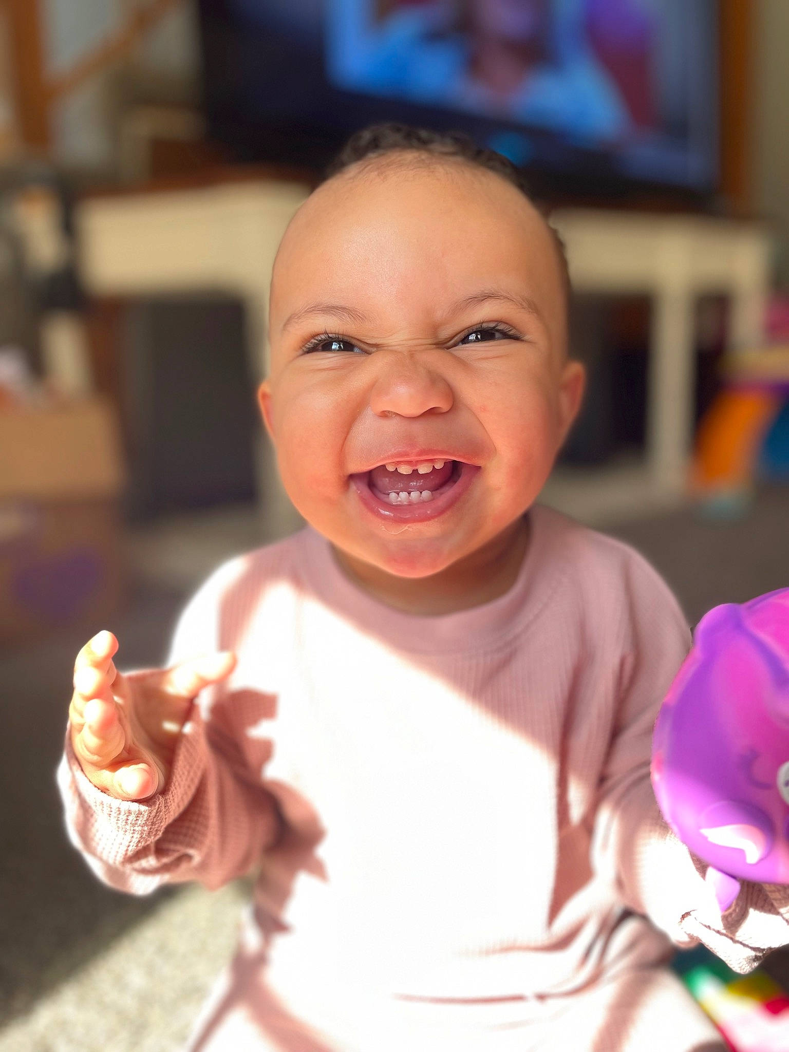 Alana is registered to the contest to win money with this photo: baby, baby_toddler_clothing, cheek, child, eating, event, finger, fun, gesture, happy, laugh, mouth, person, room, skin, smile, sweetness, television, thumb, toddler