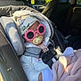 accessory, baby, blanket, car_interior, car_seat, child, clothing, cozy, cute, glasses, hat, headwear, infant, pacifier, pink, seatbelt, sitting, sunglasses, sunlight, white