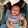 Malakai is registered to the contest to win money with this photo: baby, smiling, bib, clothing, car_seat, blanket, infant, happy, cute, blue_pants, pacifier, indoor, child, person, portrait, face, head, young, cozy, comfort