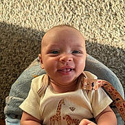 Malakai is registered to the contest to win money with this photo: baby, infant, smile, blanket, carpet, sunlight, shadow, clothing, giraffe_print, zebra_print, face, happy, cute, indoors, person, skin, hand, warm_light, closeup, portrait