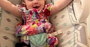 Luna joined the competition — help win amazing prizes! baby, child, infant, smiling, colorful_clothing, baby_seat, cushion, indoor, happy, person, legs, arms, head, face, fabric_pattern, home, seatbelt, playful, young_child, toddler