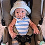 baby, child, stroller, hat, striped_clothing, smile, face, arms, hands, seatbelt, infant, blue, white, indoor, comfort, cute, person, portrait, young, sitting