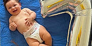 Gabriel participe au concours pour gagner de l'argent avec cette photo : baby, child, diaper, smile, happy, blue_blanket, number_balloon, silver_balloon, celebration, infant, cute, lying_down, skin, chubby, hand, foot, face, indoors, portrait, one