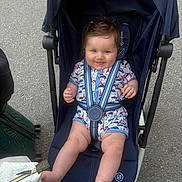 Gabriel participe au concours pour gagner de l'argent avec cette photo : baby, stroller, child, smile, outdoor, asphalt, seatbelt, clothing, bag, foot, hand, person, cute, infant, blue, fabric, zipper, expression, happy, transport